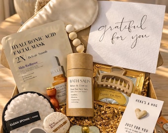 May include: A gift box filled with self-care items, including a hyaluronic acid facial mask, bath salts, a sleep mask, and a heart-shaped sponge. The box also contains a card that says "grateful for you."