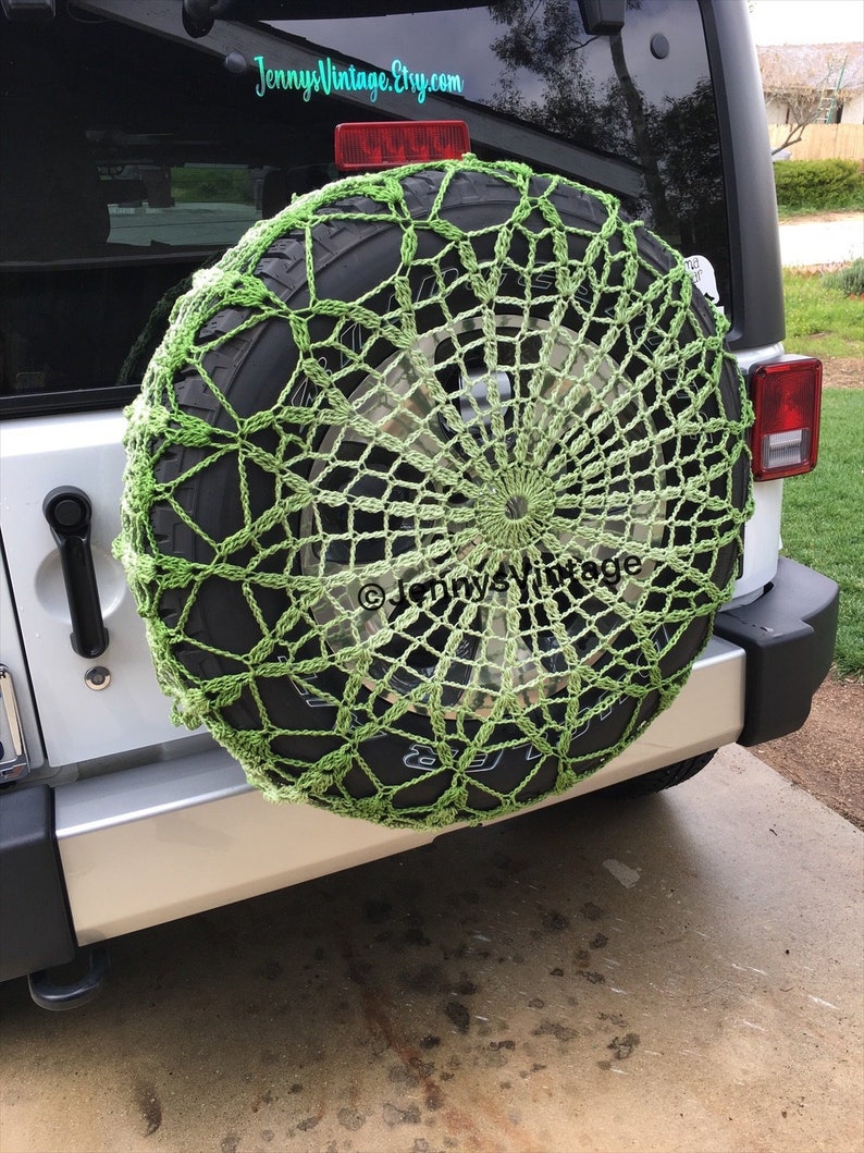 May include: A lime green crocheted spare tire cover on a vehicle. The cover has a circular, web-like design. The tire is mounted on the back of a silver SUV. The Etsy shop name "Jenny's Vintage" is visible in the image.