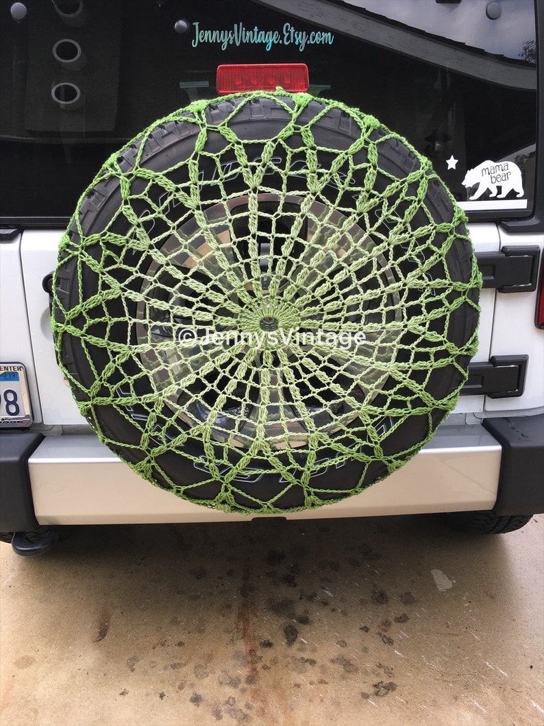 May include: A lime green crocheted spare tire cover on a black tire. The cover has a web-like design and is mounted on the back of a white SUV. The Etsy shop name "JennysVintage" is visible in the image.