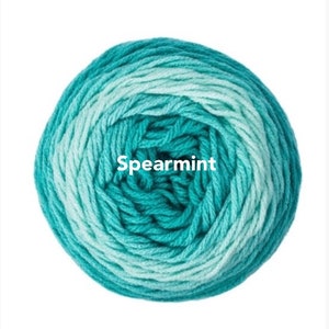 May include: A ball of Spearmint-colored yarn, featuring a gradient of teal and light blue hues. The yarn is tightly wound, creating a circular shape. The word "Spearmint" is printed in white across the center of the yarn ball.