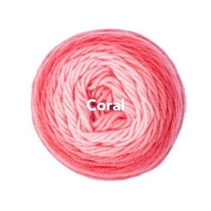 May include: A ball of coral-colored yarn, with a gradient effect from light pink to a deep coral hue. The word "Coral" is printed in white across the center of the yarn ball. Ideal for knitting and crochet projects.