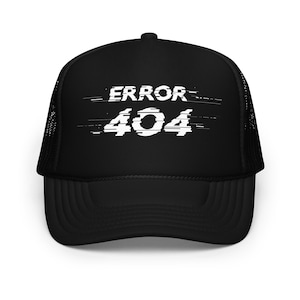 May include: A black trucker hat featuring a white graphic print on the front panel. The design displays the text ERROR 404 in a stylized, digital glitch font with horizontal lines running through the letters. The cap has a solid front and mesh back.