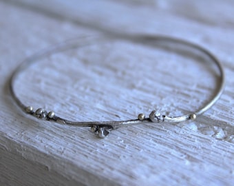 Pulsera de plata de ley oxidada con ramitas y puntos de oro de 18 quilates