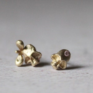 Peut inclure: Une paire de boucles d'oreilles en forme de cr&acirc;ne en or. L'une des boucles d'oreilles a un petit d&eacute;tail d'aile sur le c&ocirc;t&eacute; du cr&acirc;ne.