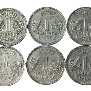 Puede incluir: Seis monedas de plata de 1 rupia india. Cada moneda presenta el número 1, la palabra "RUPEE" y el año de acuñación: 1962, 1975, 1976, 1977, 1981 y 1982. Las monedas tienen un diseño de espiga de trigo.