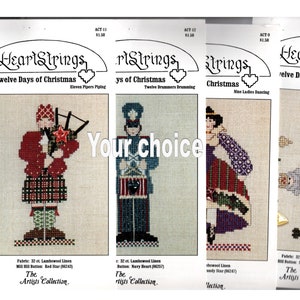 May include: Four cross-stitch patterns for the Twelve Days of Christmas. Each pattern features a different scene from the song, including a piper, a drummer, a lady dancing, and a lord a-leaping. The patterns are printed on white paper with a red heart logo and the text "HeartStrings" at the top.
