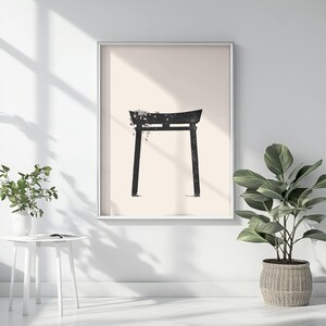 May include: A black and white minimalist print of a traditional Japanese torii gate with a floral design. The gate is set against a light beige background.