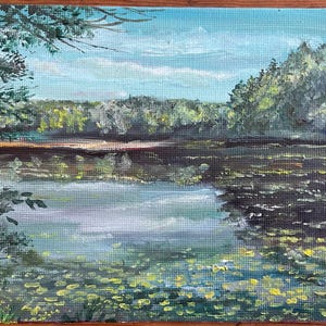 May include: An original oil painting of a serene lake scene. The artwork depicts a calm body of water reflecting the sky and surrounding trees. The painting features a blue sky with clouds, lush green trees, and yellow lily pads.