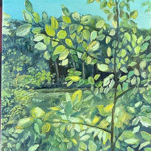 May include: Oil painting of a serene landscape featuring a body of water and lush greenery. The artwork showcases a vibrant palette of greens and yellows, with a light blue sky peeking through the foliage. The painting captures a tranquil outdoor scene.