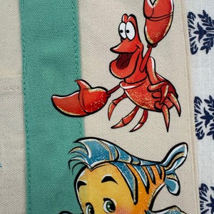 Bolsa pequena personalizada da Trader Joe's com os personagens da Ariel, Sebastião e Linguado da Disney. imagem 3