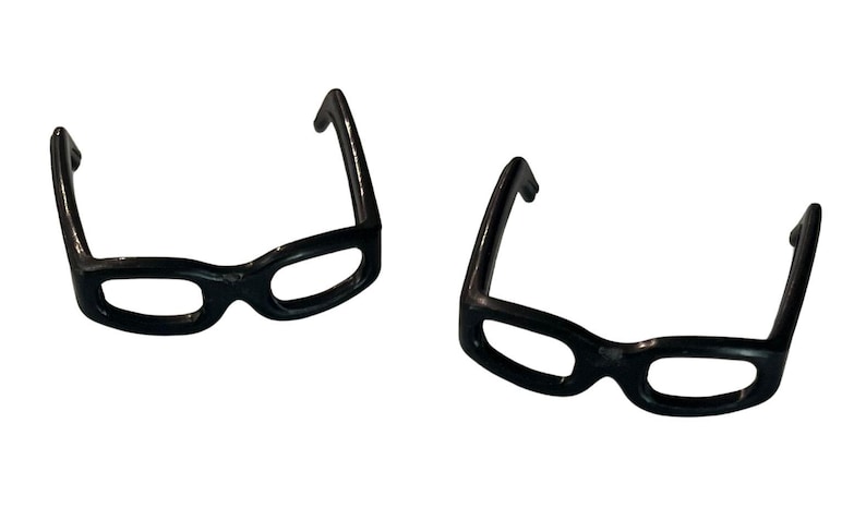 May include: Two pairs of black, thick-framed eyeglasses are displayed against a white background. The glasses have a classic, rounded shape with a glossy finish. The frames are a solid, opaque black.