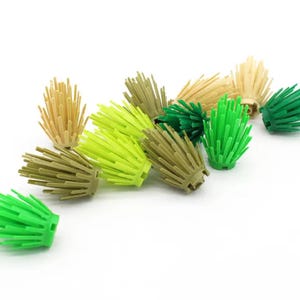 Puede incluir: Surtido de piezas de follaje de plástico verde, amarillo y marrón para la construcción de modelos. Las piezas están diseñadas para parecerse a diferentes tipos de hierba y follaje.