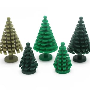 Könnte beinhalten: Fünf kleine Weihnachtsbäume aus Plastik in verschiedenen Grüntönen und Braun. Die Bäume sind aus Lego-Steinen gefertigt und in einer Reihe auf einer weißen Oberfläche angeordnet.