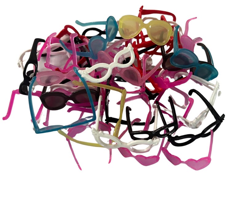 May include: A pile of small, colorful toy sunglasses in various shades, including black, white, pink, blue, and yellow. The sunglasses have different frame styles and are made of plastic. The image is taken against a white background.