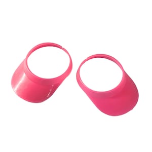 May include: Two pink plastic visor hats. The hats are designed to fit over a beverage can or bottle.
