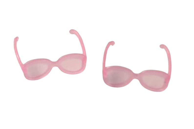 May include: Two pairs of light pink sunglasses with rounded frames and curved temples. The lenses are a lighter shade of pink. The sunglasses are set against a white background.