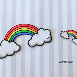 May include: Two embroidered iron-on patches featuring a rainbow with clouds. The larger patch has a full rainbow arc, while the smaller patch has a partial rainbow arc.