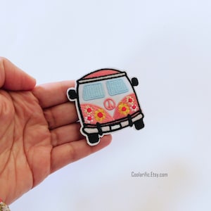 May include: Pink and white embroidered iron-on patch of a vintage van with peace sign and flowers. CoolariificEtsy.com