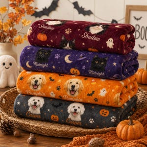 May include: A stack of four folded fleece blankets featuring Halloween-themed prints. The top blanket is maroon with cats and pumpkins, the second is purple with cats and moons, the third is orange with dogs, and the bottom is dark gray with dogs.