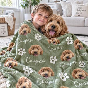 May include: A sage green plush throw blanket featuring a repeating pattern of a golden doodle dog's face, white paw prints with heart-shaped pads, and the name Cooper written in a white cursive script across the soft, textured fabric surface.