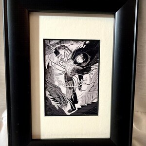 May include: Black framed artwork featuring a detailed black and white illustration. The artwork depicts a figure with intricate details, surrounded by abstract elements. The frame is a simple, rectangular design, adding a classic touch to the piece.