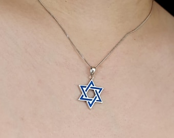 May include: A silver chain necklace with a blue enamel Star of David pendant.