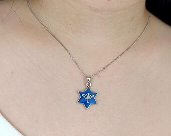 May include: A silver chain necklace with a blue enamel Star of David pendant featuring a menorah design.