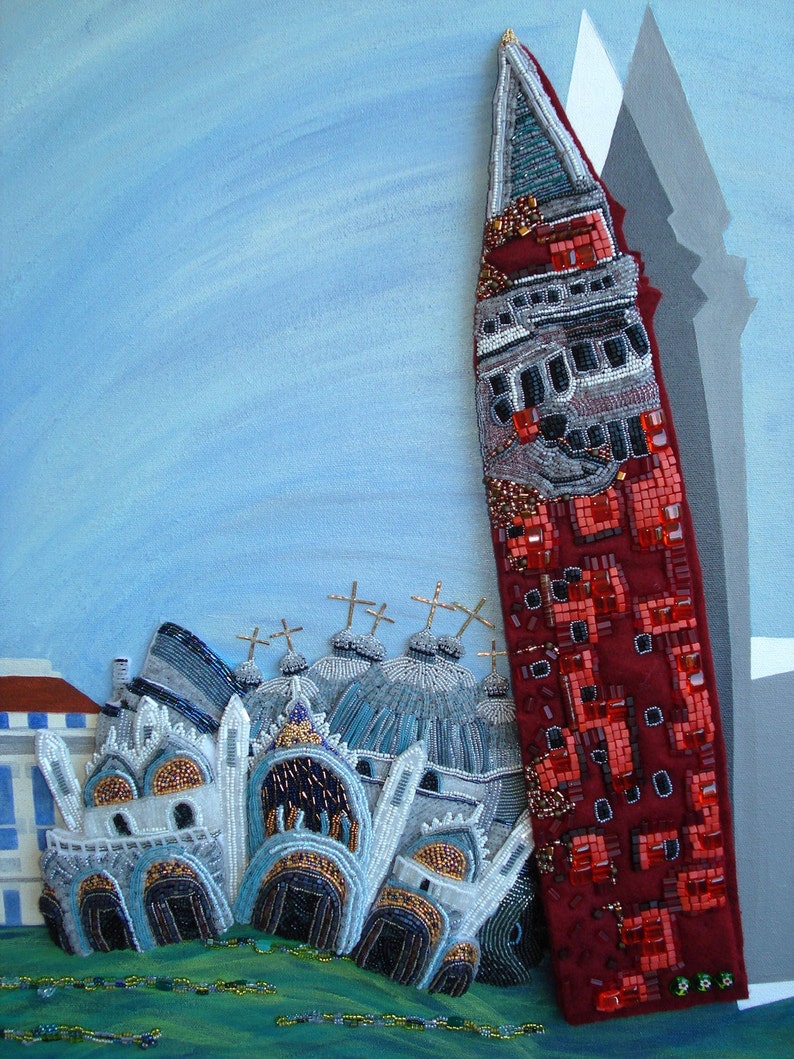 May include: A beaded artwork depicting a cityscape with a tall red building and several white buildings with domes. The artwork is made with beads of various colors and sizes, creating a textured and detailed effect.
