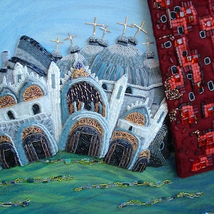 May include: A beaded artwork depicting a cityscape with multiple white buildings with blue and gold accents. The buildings have domes and crosses on top. The background is a light blue sky. A red beaded panel is on the right side of the image.