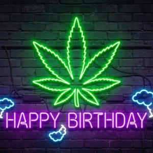 Könnte beinhalten: Ein Neonschild mit einem grünen Cannabisblatt und den Worten "HAPPY BIRTHAY" in Lila. Das Schild befindet sich vor einer dunklen Backsteinmauer mit blauen Akzenten um den Text.