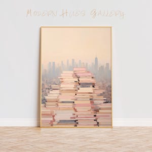 May include: A framed painting of a city skyline with a stack of books in the foreground. The books are stacked in a pyramid shape and are all different colors. The city skyline is in the background and is a hazy, muted color. The painting is in a gold frame.