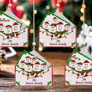 Adorno de muñeco de nieve de feliz Navidad Svg, nombre de familia personalizado Svg, letra de Navidad personalizada Svg, percha familiar de muñeco de nieve de madera, archivo cortado con láser