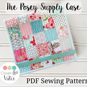 May include: A PDF sewing pattern for a patchwork fabric supply case. The case is made of a variety of pink, blue, and white fabrics with a floral design. The case is called "The Posey Supply Case" and is by Clover & Violet.