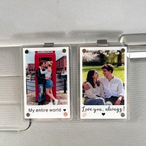 May include: Two clear acrylic photo displays with attached clips. Each display holds a photo with a white border. One photo shows a couple in front of a red telephone box. The other shows a couple on a bench. Text reads "My entire world" and "Love you, always!"
