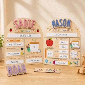 May include: Two arched wooden signs for the first day of school, personalised with the names Sadie and Mason in raised letters. The boards feature sections for grade, date, age, teacher, and favourites, decorated with colourful school-themed icons.