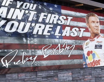 May include: A banner with an American flag design featuring the text "If you ain't first you're last" and a signature that reads "Ricky Bobby". A man in a racing suit is pictured on the right side of the banner.