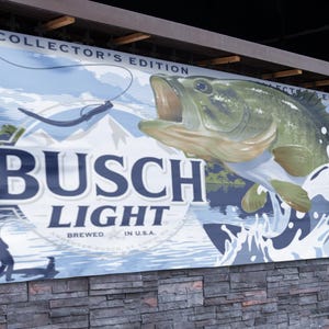 May include: A blue and white banner with the text "Busch Light" and a largemouth bass jumping out of the water. The banner also says "Collector's Edition" and "Brewed in U.S.A."