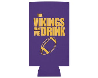 May include: Purple can cooler with the text "The Vikings Make Me Drink" in yellow with a yellow football graphic.