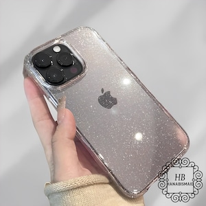 May include: A clear phone case with a sparkly silver glitter design. The case is designed for an iPhone with a triple lens camera and Apple logo.
