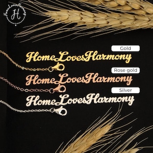 May include: Three nameplate necklaces in gold, rose gold, and silver, each featuring the script text HomeLovesHarmony. Each necklace includes a delicate chain with a lobster claw clasp. The labels Gold, Rose gold, and Silver are visible.
