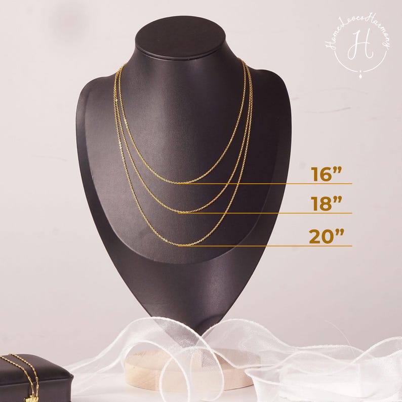 May include: Three gold-toned chain necklaces displayed on a black mannequin bust. The chains are layered at lengths of 16 inches, 18 inches, and 20 inches, as indicated by horizontal lines and text labels next to each individual necklace strand.