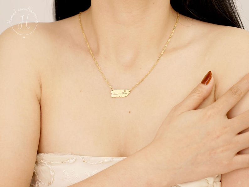 May include: A gold-toned necklace featuring a delicate chain and a small, flat pendant shaped like the island of Puerto Rico. The pendant is engraved with the text 'Culebra, Puerto Rico' and includes a tiny heart symbol near the text.