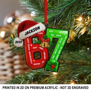 May include: A Christmas tree ornament with a red and green design. The red ornament is shaped like the number 6, with a Santa hat that says "Jackson" and the year "2025". The green ornament is shaped like the number 7.