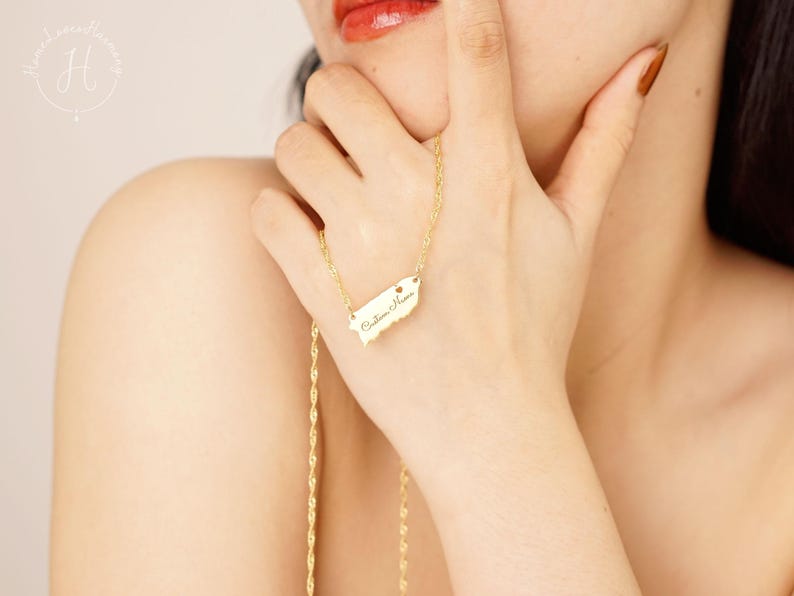 May include: A gold-toned necklace featuring a pendant shaped like the island of Puerto Rico. The pendant is engraved with the cursive text 'Custom Name' and includes a small heart symbol. The necklace has a twisted rope chain design.