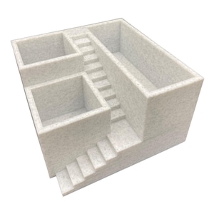 Könnte beinhalten: Ein hellgrauer, strukturierter Schreibtisch-Organizer mit einem einzigartigen architektonischen Design. Er verfügt über mehrere Fächer und Treppen, wodurch eine optisch interessante und funktionale Aufbewahrungslösung entsteht. Der Organizer besteht aus einem gesprenkelten Material.