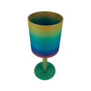 May include: A goblet with a textured surface featuring a vertical colour gradient that transitions from a golden yellow at the rim through shades of teal and blue to a deep purple at the base of the bowl, supported by a solid green stem and base.