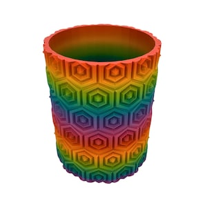 May include: A cylindrical container with a honeycomb pattern in a rainbow of colors. The rim and interior are also multi-colored, creating a vibrant and eye-catching design. The container is made of a solid material.