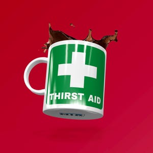 Può includere: Una tazza in ceramica bianca con un segno di pronto soccorso verde e bianco e il testo "THIRST AID".