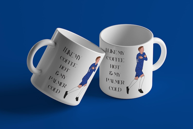 May include: Two white ceramic mugs with black text and a blue cartoon figure. The text on the mugs reads "I like my coffee hot & my Palmer cold".