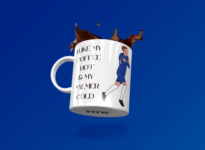 May include: White ceramic mug with a blue and white illustration of a soccer player. The mug has black text that reads "I like my coffee hot & my Palmer cold".